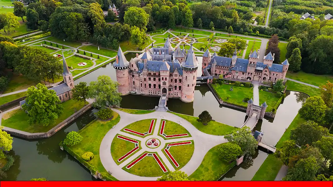 Professionele dronefotografie van Kasteel de Haar in Haarzuilens – Majestueus luchtschot voor architectuur- en eventportfolio. Deze indrukwekkende overzichtsfoto, gemaakt met een drone, toont het iconische Kasteel de Haar in volle glorie. De opname is een perfect voorbeeld van hoogwaardige architectuurfotografie en luchtfotografie, waarbij het kasteel, de omliggende slotgracht en de strakke kasteeltuinen in één compositie zijn gevangen. Technisch vakmanschap: De foto demonstreert een uitstekende beheersing van licht en kleurverzadiging, waardoor de rode luiken en de bakstenen details van het kasteel prachtig afsteken tegen het levendige groen van het landgoed. Compositie: Het standpunt benadrukt de schaal van het grootste kasteel van Nederland. Op de voorgrond is een groot cirkelvormig gazon met een stervormig bloemenpatroon te zien, dat de kijker via de ophaalbrug naar de centrale torens van het kasteel leidt. Toepassing: Dit beeld illustreert de expertise van de fotograaf in het vastleggen van exclusief vastgoed, historische monumenten en grootschalige evenementlocaties vanuit de lucht.